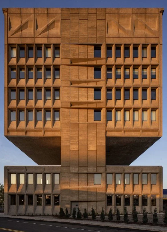 Brutalist facade of Hotel Marcel in New Haven, Connecticut, with cantilevered upper floors and deep-set windows.