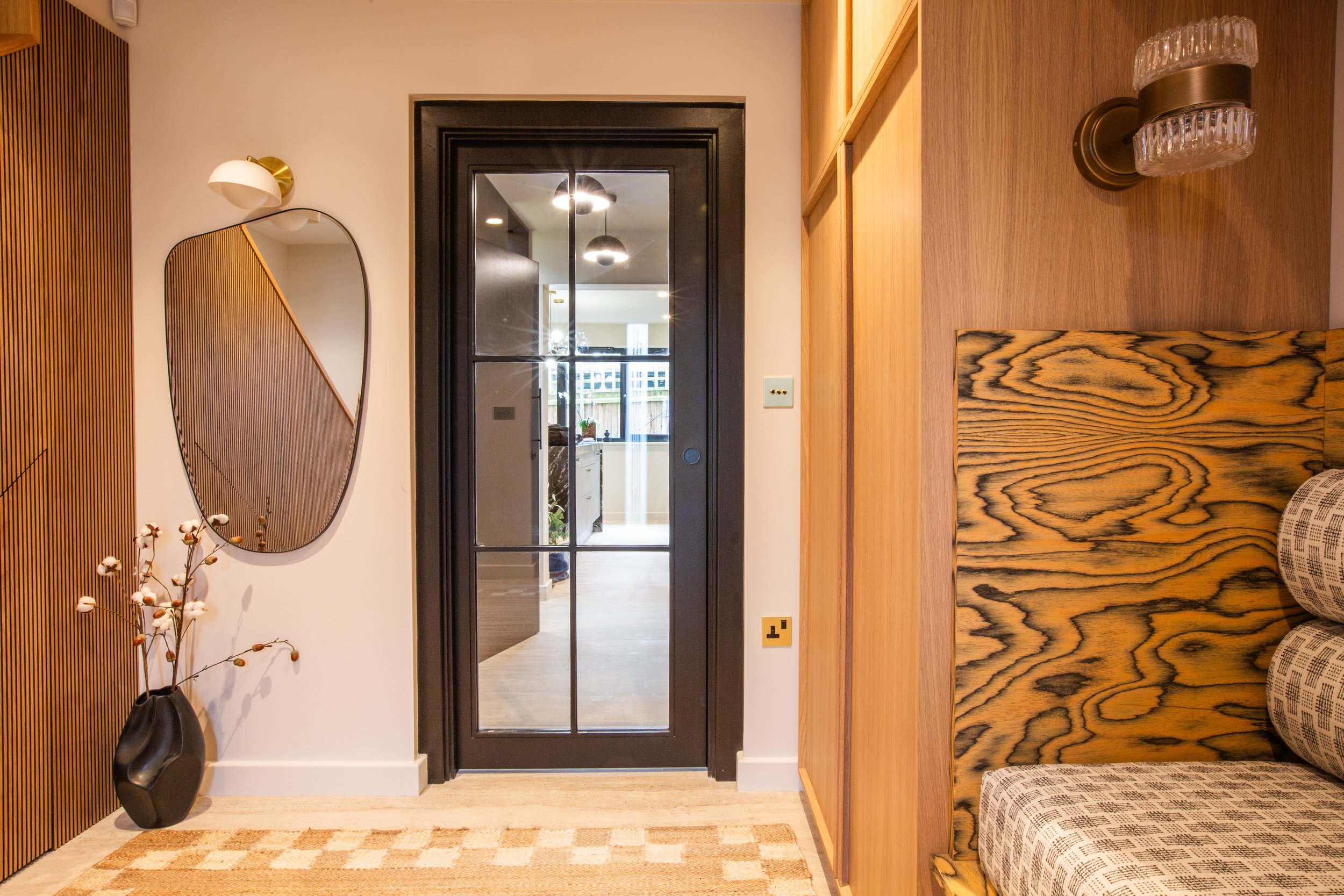 Made‑to‑measure hallway storage in a Shelford home, hidden behind a flush door to create a clean, modern entrance with seamless built‑in cabinetry.
