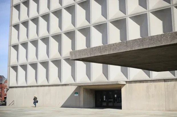 Brutalist facade of IBM France headquarters in Paris designed by Marcel Breuer, with square recesses and concrete overhang.