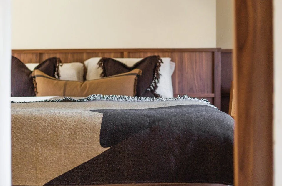 Japandi bedroom detail in a Grade II listed South Cambridgeshire home with layered textiles and warm wood