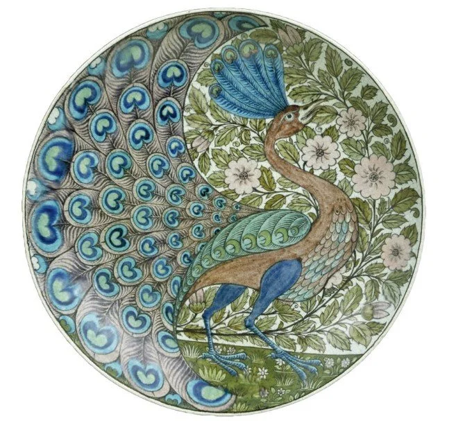 Arts and Crafts ceramic plate by William De Morgan, featuring a hand-painted peacock and floral motifs that reflect the decorative richness of heritage interiors in Cambridge.