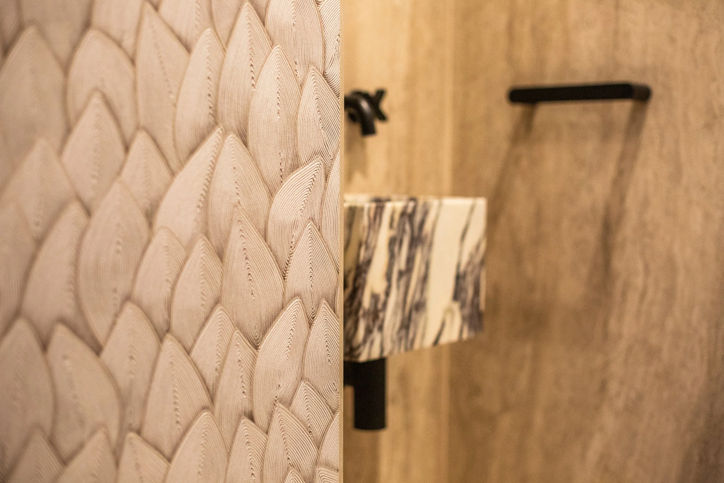 Modern bathroom with Elitis vinyl wallpaper, marble sink, and black fixtures — a tactile, wipeable design that blends elegance with practicality.