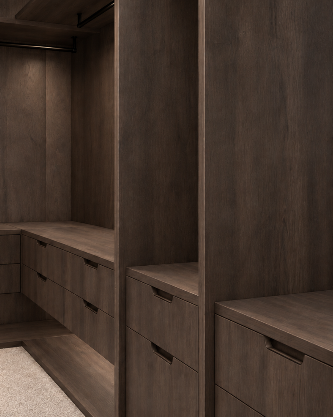 Detail of bespoke dark timber walk-in wardrobe joinery in Cambridge, showing integrated drawer handles, open shelving and hanging space.
