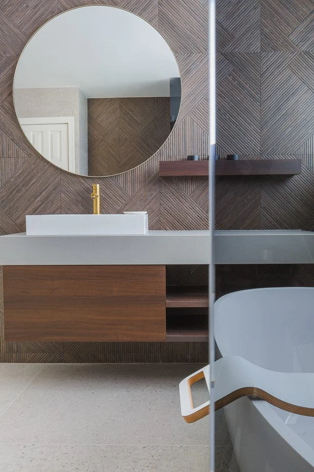 South Cambridgeshire bathroom renovation with a Cox & Cox mirror, Lusso Stone brushed brass tap and Porcelanosa textured tiles.