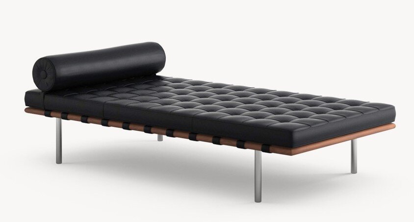 Modernist black leather daybed with bolster pillow and metal legs — minimalist design by Mies van der Rohe.