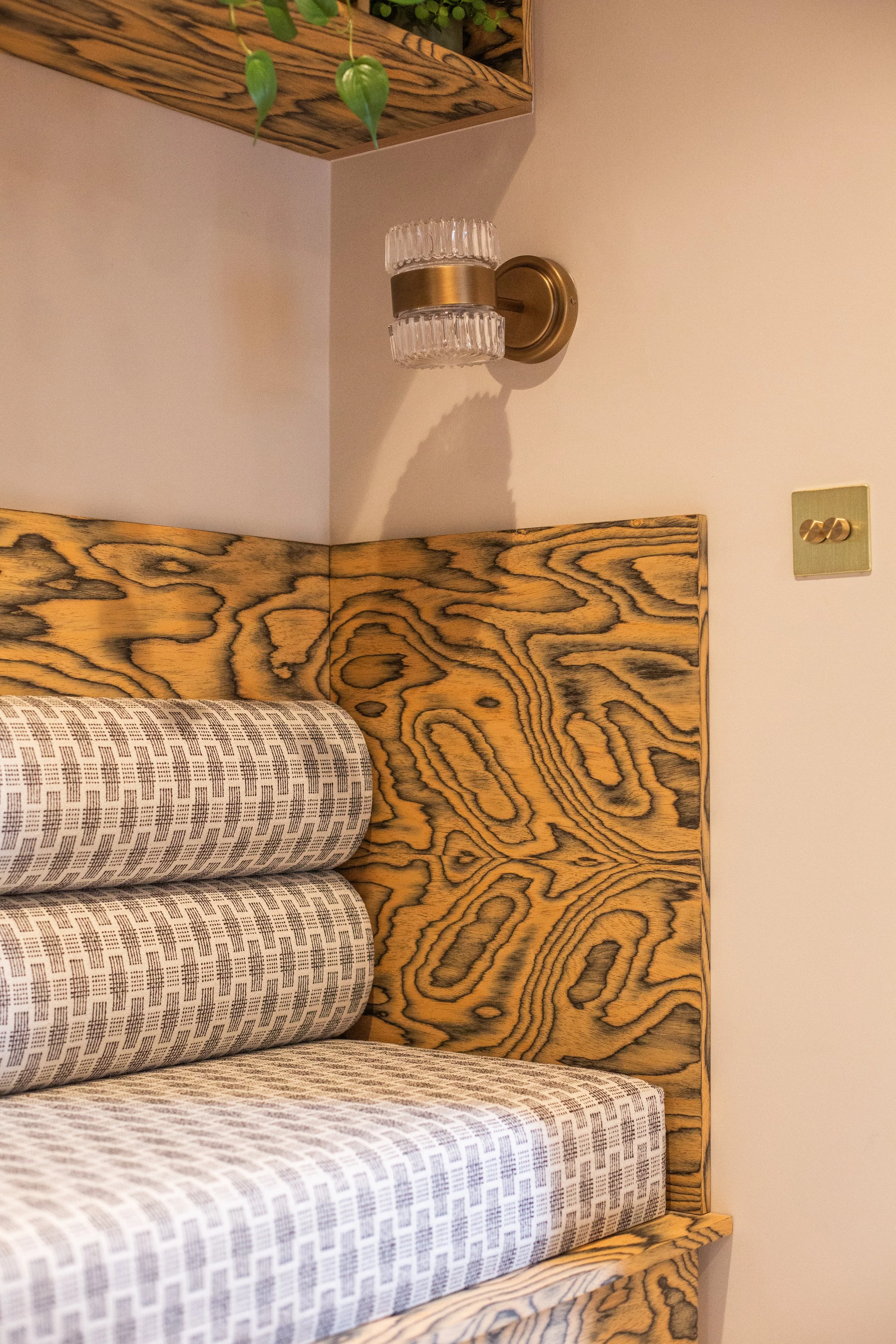 Shelford hallway with figured wood bench, brass lighting, and geometric textiles — SBID 2025 winner.