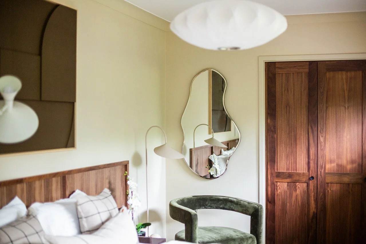 Built‑in wardrobe in the Gamlingay renovation guest bedroom, showing a seamless storage solution with wooden doors, sculptural lighting and a calm modern aesthetic.
