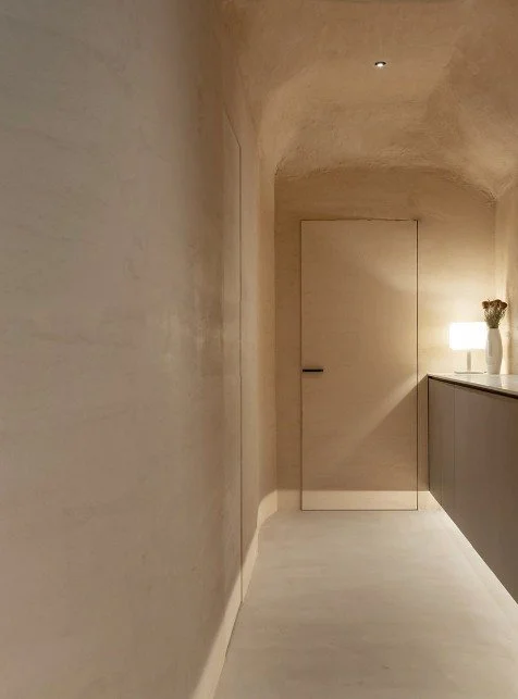 Minimalist hallway with lime plaster walls and ceiling, showing breathable finish and architectural softness.