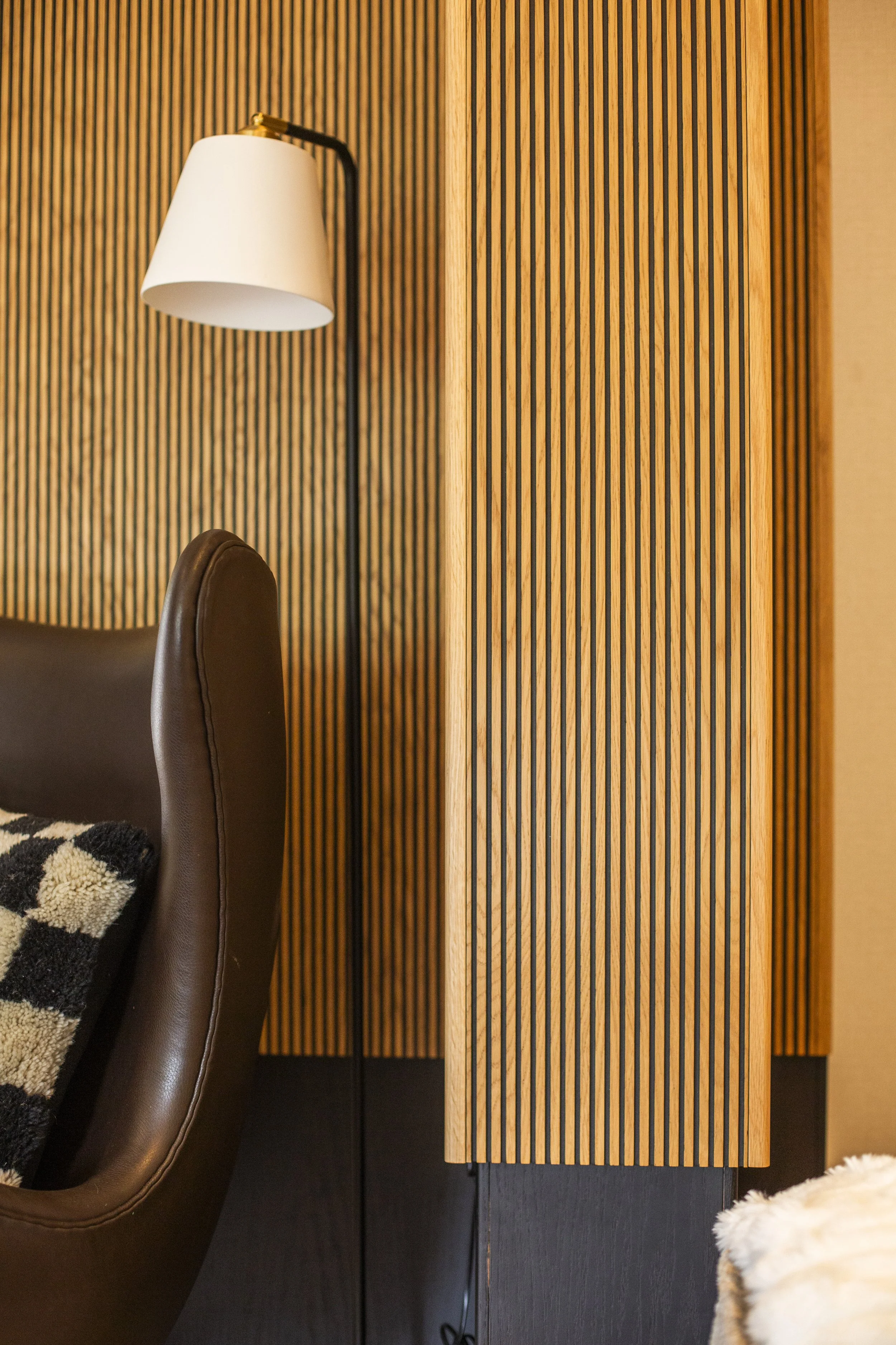 Wall panelling detail in Shelford project featuring layered wood textures and modern interior styling