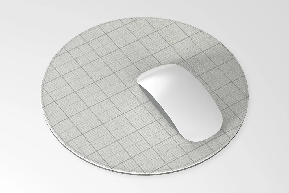 White computer mouse on round grid-patterned mouse pad
