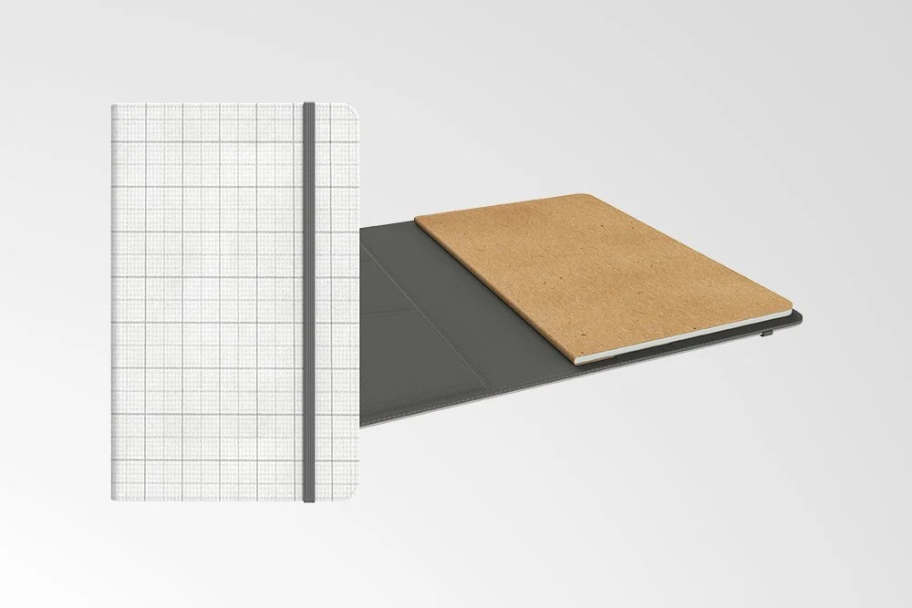 Two notebooks on a white background. One is closed with a grid pattern cover and elastic band, the other is open with a brown kraft paper cover.