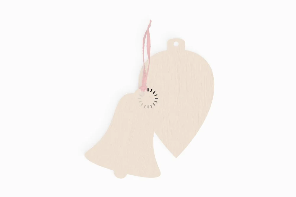 Light wooden bell-shaped and heart-shaped ornaments with pink ribbon.