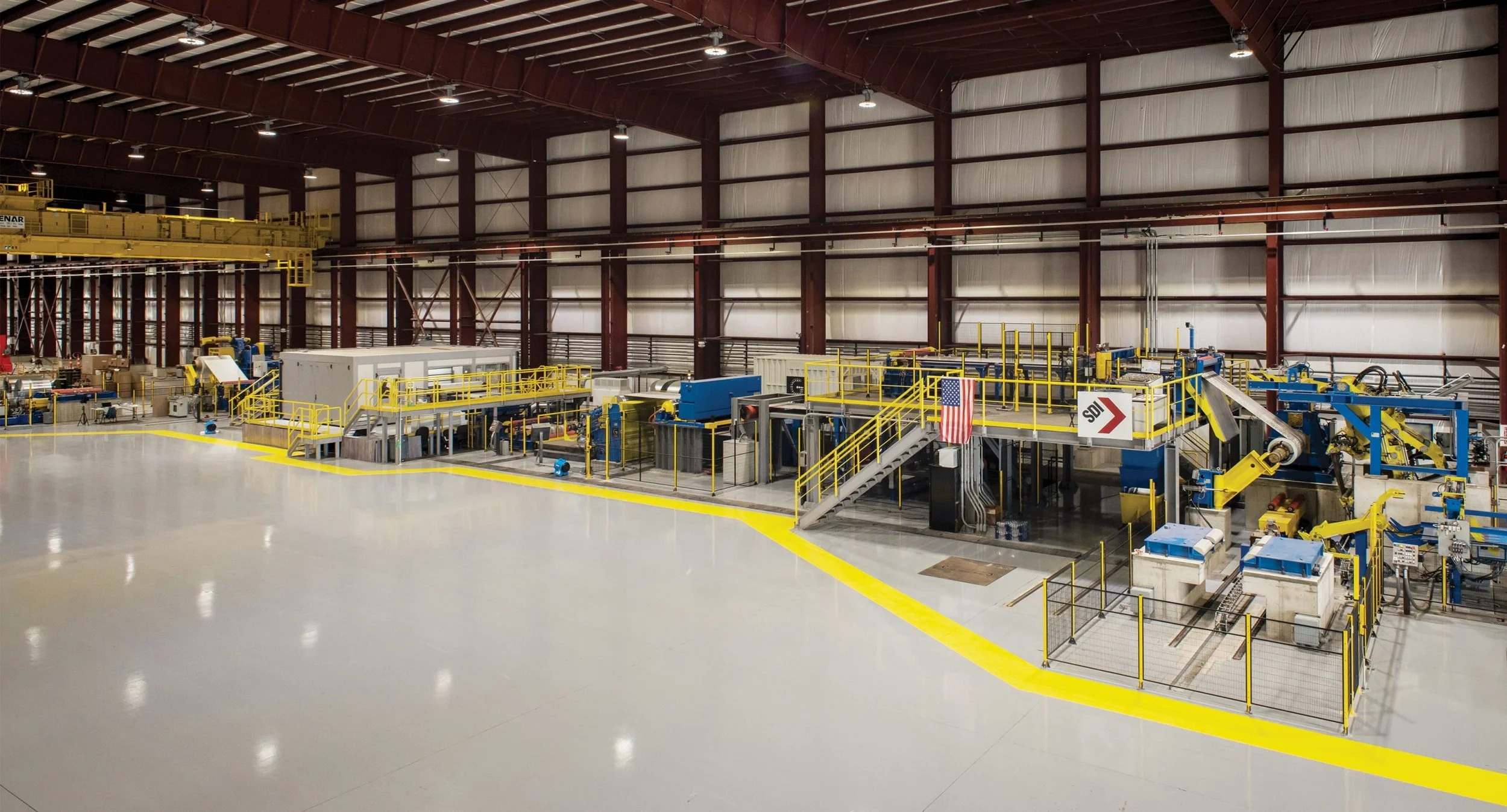 A beautiful gray painted floor with safety yellow walkways in an industrial facility.