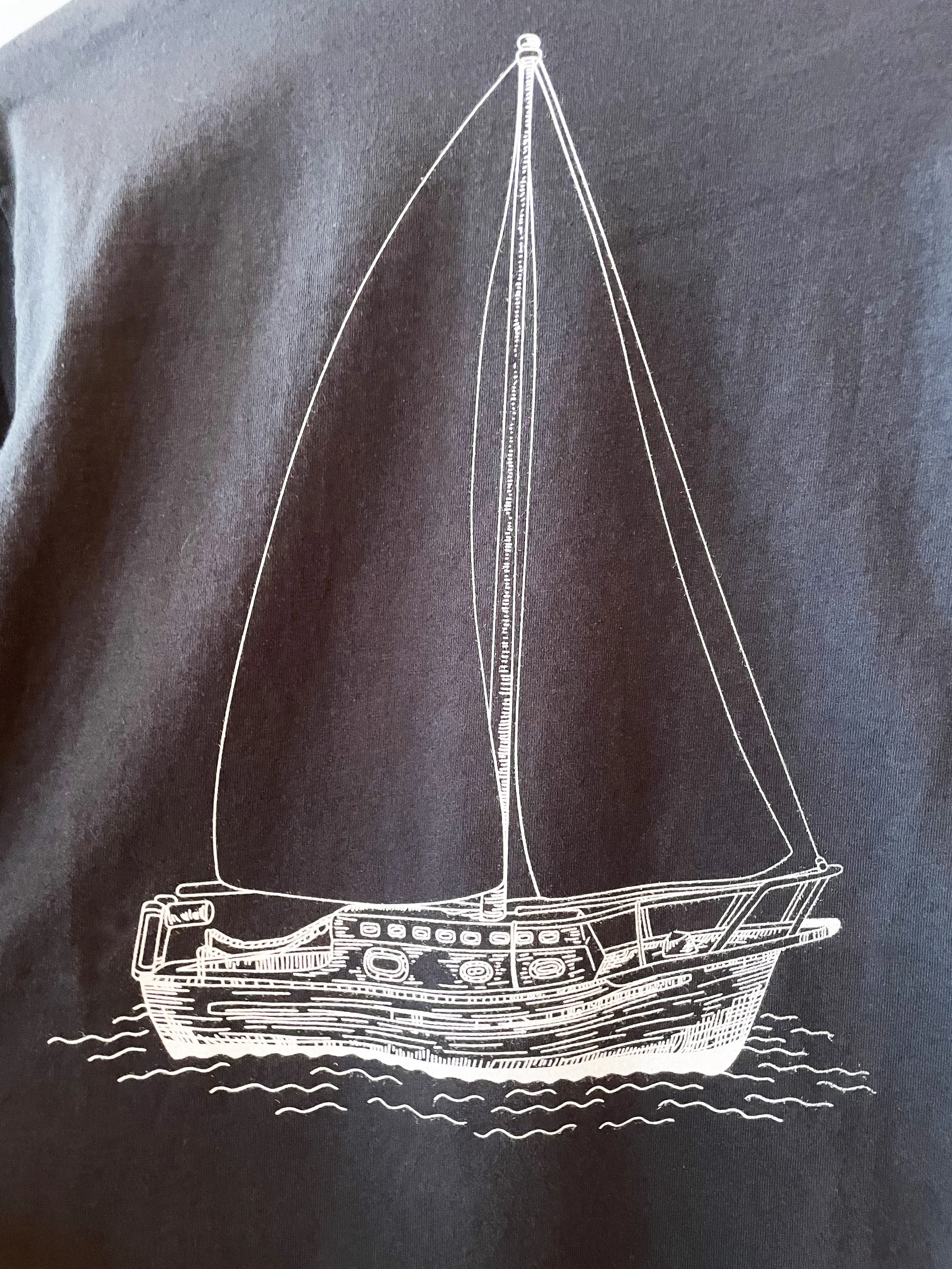 White line drawing of a sailboat with two sails on dark background.