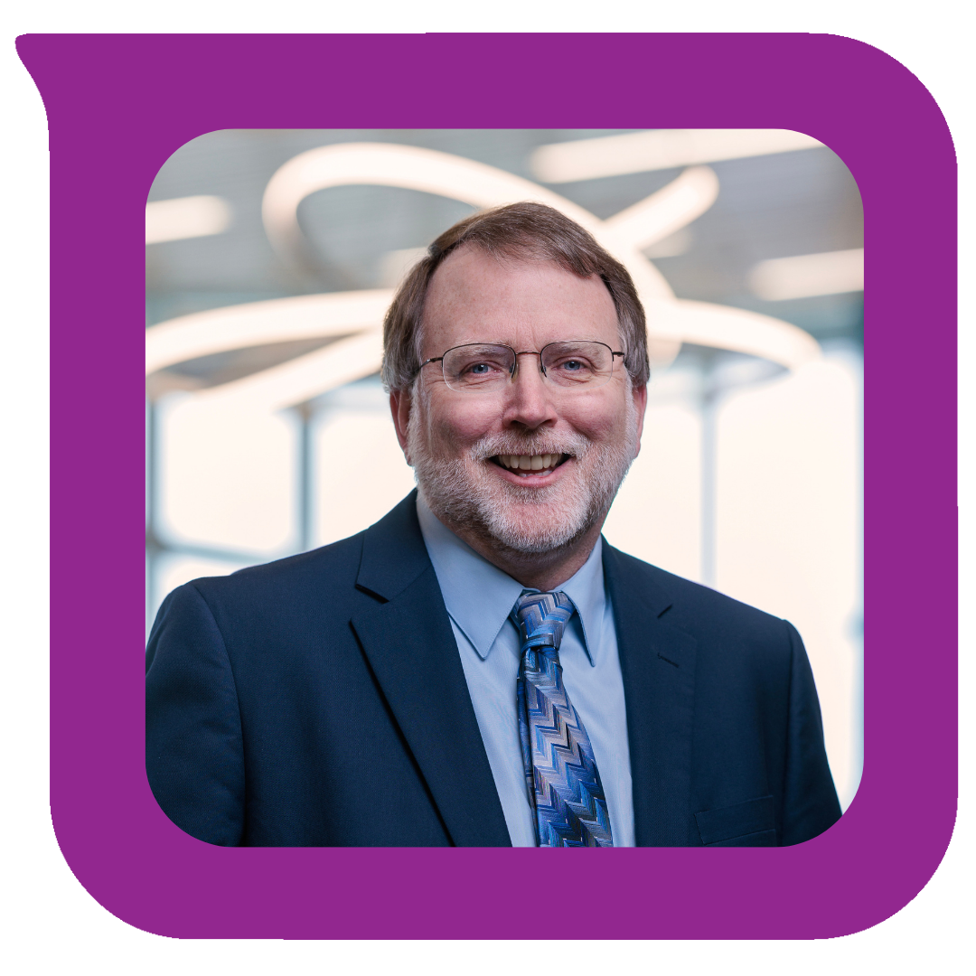 မျက်မှန်၊ မုတ်ဆိတ်နှင့် မီးခိုးရောင်ဆံပင်ရှိသော အသက်လတ်ပိုင်းအရွယ် အမျိုးသားတစ်ဦးသည် စီးပွားရေးဝတ်စုံနှင့် နက်ကတိုင်ကို ဝတ်ဆင်ထားပြီး ခေတ်မီမီးအိမ်များ နောက်ခံတွင် ရုံးခန်းပတ်ဝန်းကျင်တွင် ရှိနေခဲ့သည်။