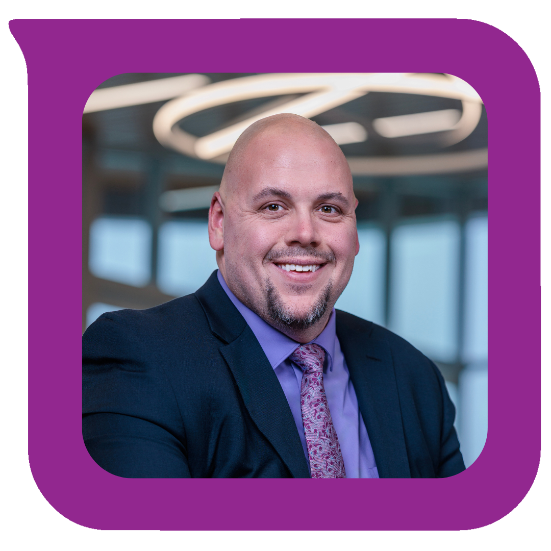 ခေတ်မီရုံးခန်းနောက်ခံနှင့် စက်ဝိုင်းပုံမျက်နှာကျက်မီးများပါရှိသော ဝတ်စုံနှင့် တိုင်ဝတ်ဆင်ထားသော ပြုံးရွှင်နေသောအမျိုးသားတစ်ဦး၏ ပရော်ဖက်ရှင်နယ်ပုံတူ။