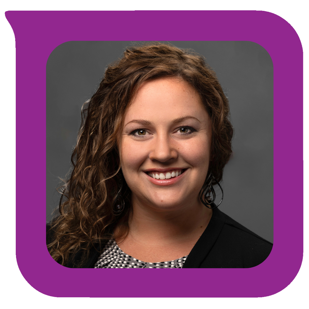 မီးခိုးရောင်နောက်ခံတွင် အနက်ရောင်ဘလေဇာအင်္ကျီနှင့် ပုံစံအင်္ကျီကို ဝတ်ဆင်ထားပြီး ကောက်ကွေးသော အညိုရောင်ဆံပင်နှင့် ပြုံးရွှင်နေသော အမျိုးသမီးတစ်ဦး၏ ခေါင်းစီးဓာတ်ပုံ။