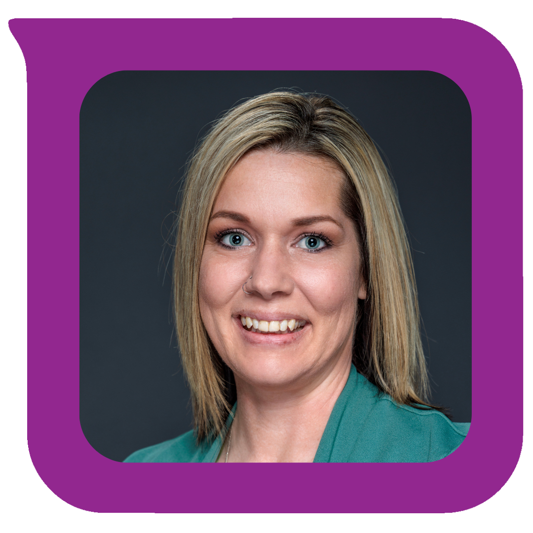 ရွှေရောင်ဆံပင်၊ အပြာရောင်မျက်လုံးနှင့် နှာခေါင်းပေါက်ပါသော အမျိုးသမီးတစ်ဦးသည် အပြာရောင်အင်္ကျီဝတ်ဆင်ထားပြီး နောက်ခံတွင် ပြုံးနေပုံ။