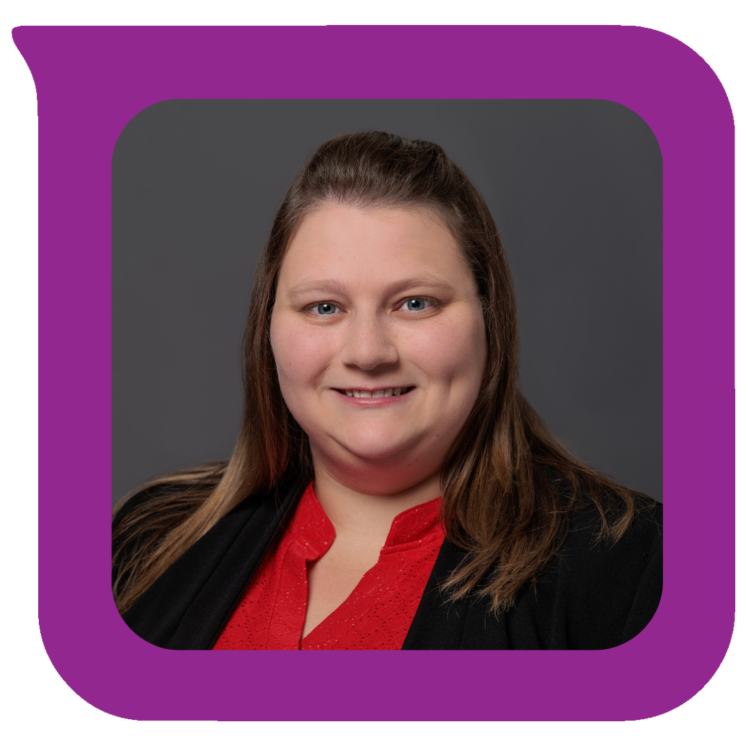 အညိုရောင်ဆံပင်၊ အပြာရောင်မျက်လုံး၊ အနက်ရောင်ဘလေဇာနှင့် အနီရောင်အပေါ်အင်္ကျီဝတ်ဆင်ထားသော အမျိုးသမီးတစ်ဦး၊ မီးခိုးရောင်နောက်ခံတွင် ပြုံးရွှင်နေပုံ၏ ပရော်ဖက်ရှင်နယ်ပုံတူ။