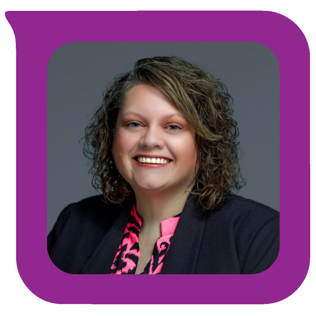 အနက်ရောင် ဘလေဇာအင်္ကျီနှင့် ပန်းရောင်နှင့် အနက်ရောင် ပုံစံ ဘလောက်စ်အင်္ကျီကို ဝတ်ဆင်ထားသော ကောက်ကွေးပြီး ပခုံးအထိရှည်သော ဆံပင်နှင့် အမျိုးသမီးတစ်ဦးသည် ရိုးရိုးမီးခိုးရောင်နောက်ခံတွင် ကင်မရာရှေ့တွင် ပြုံးနေသည်။