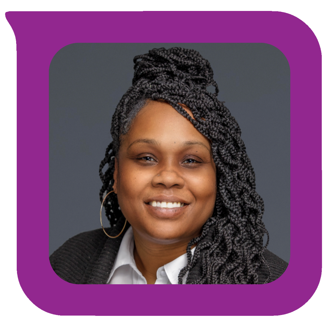 Portrait of a smiling Black woman with gray patterned braids, hoop earrings, wearing a white shirt and black blazer, against a gray background.