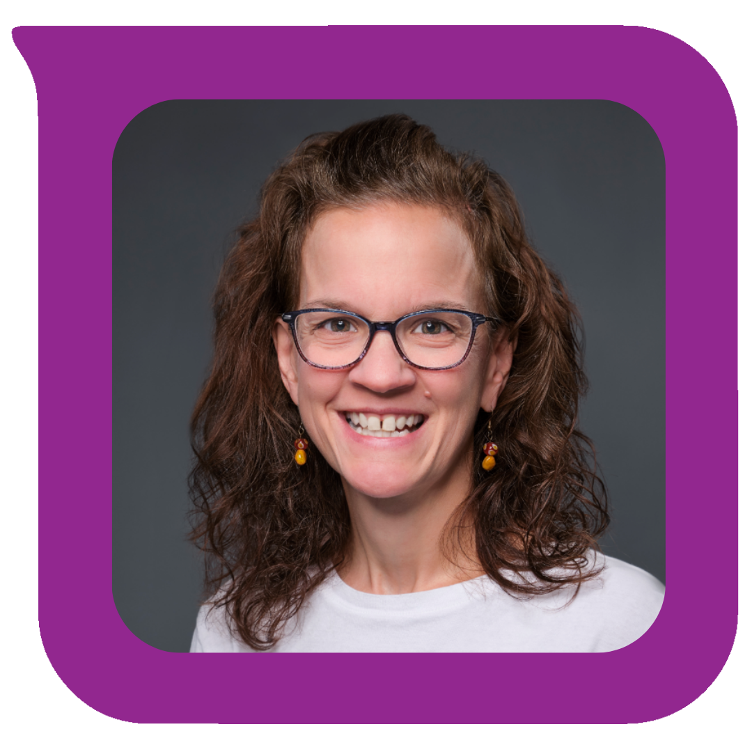 A woman with curly brown hair, glasses, and earrings smiling against a dark grey background.