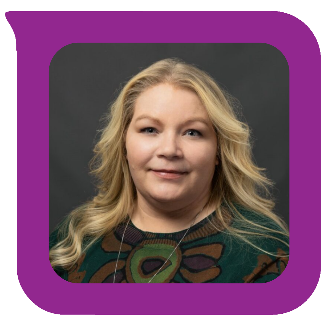 A woman with blonde wavy hair, wearing a dark green top with abstract brown and purple patterns, smiling slightly, against a dark grey background.