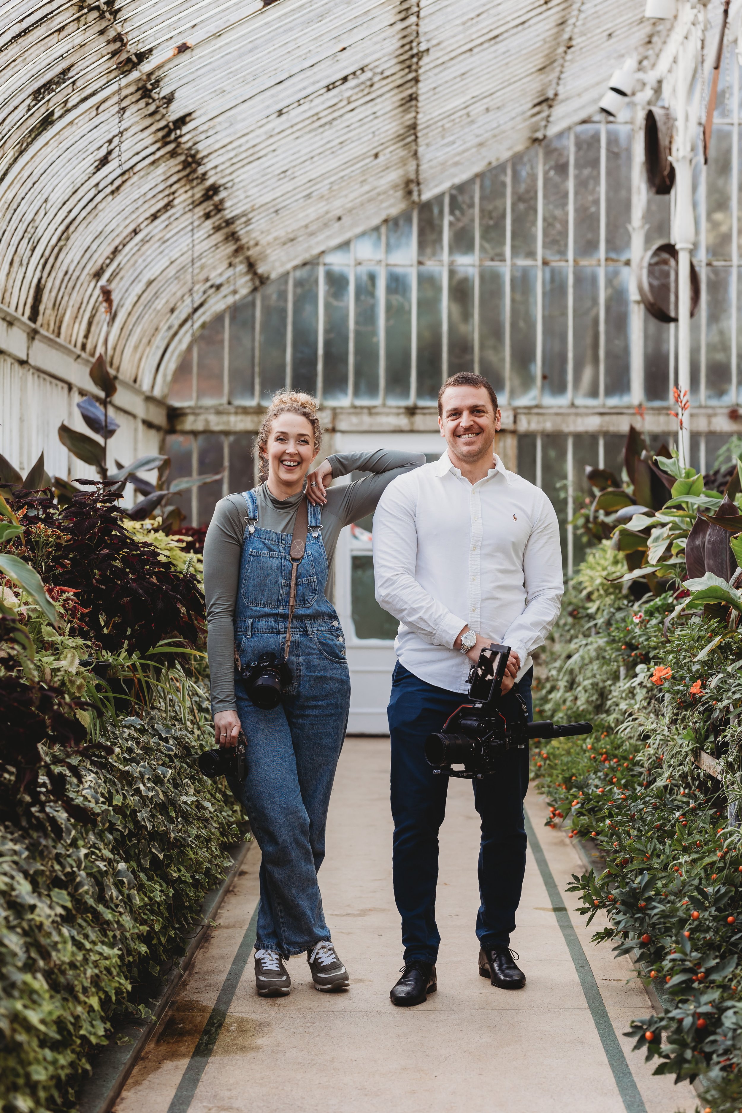 wedding photographer and wedding videographer stood next to each other inside a greeenhouse botanical garden in belfast