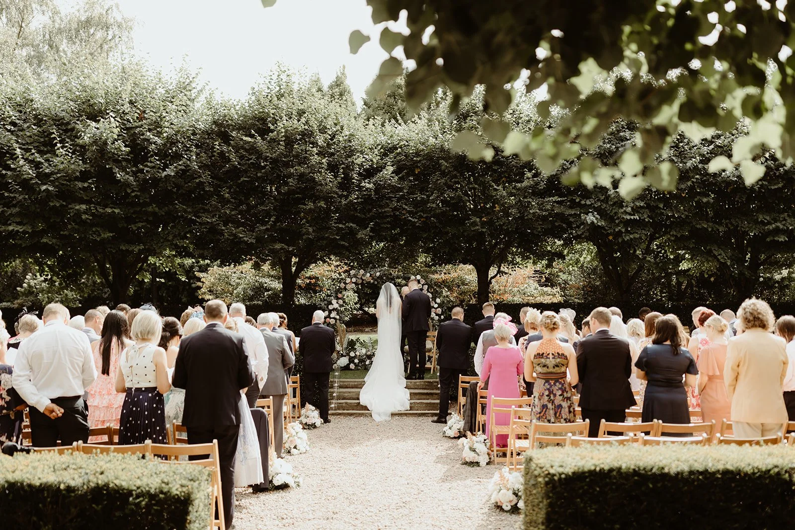 bride, groom and guests at an outdoor ceremony in the grounds of larchfield estate