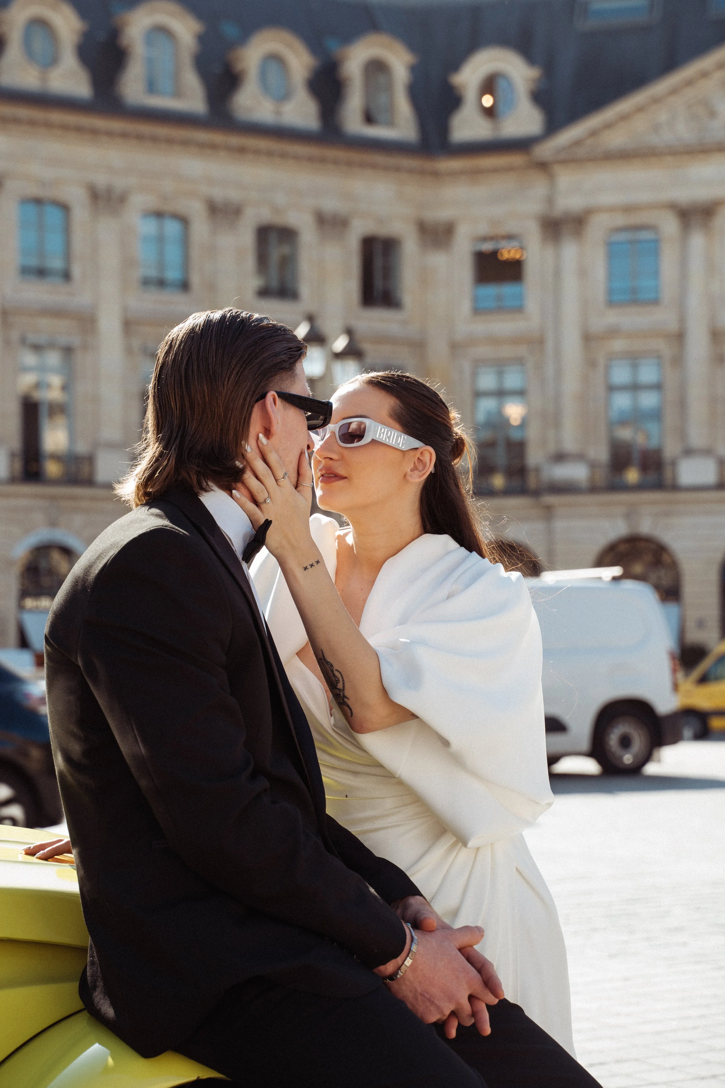 man and wife sat on a fountain on the streets of paris