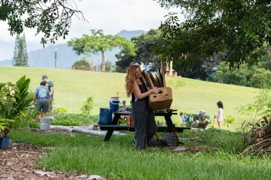 Sari brings donated cardboard to volunteers in Wailua forest garden.