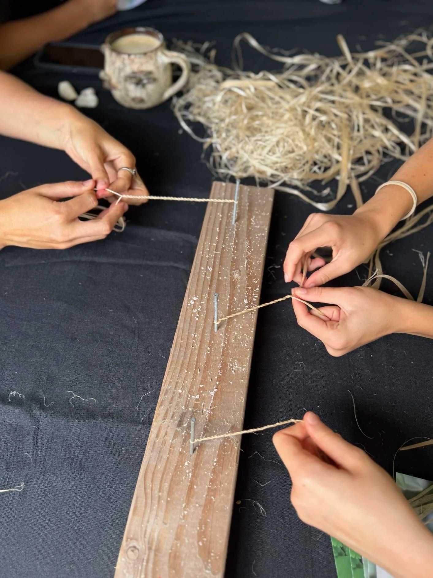 Hands twisting the inner bark of hau to make cordage