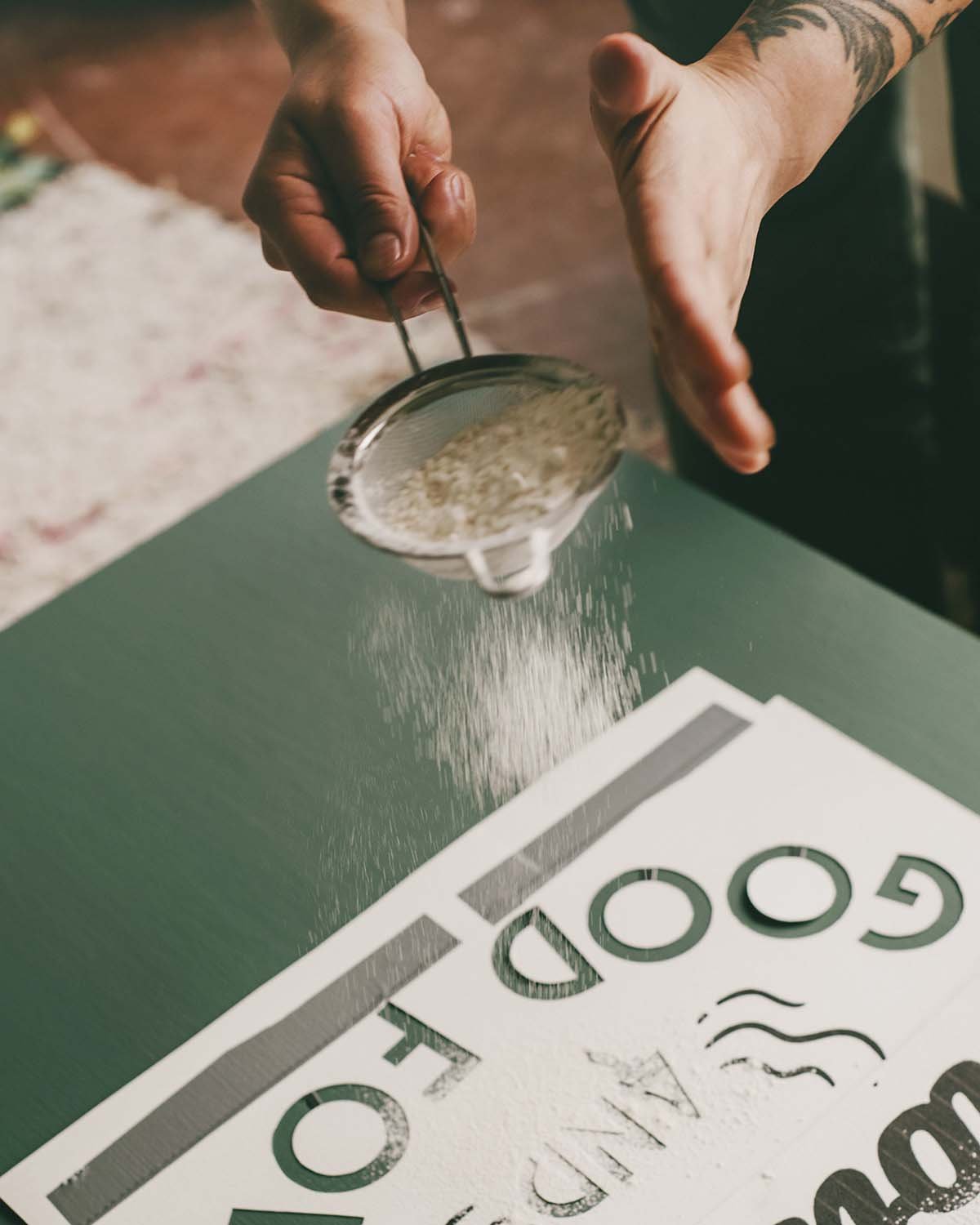 Lauren sifts flour over stencil.