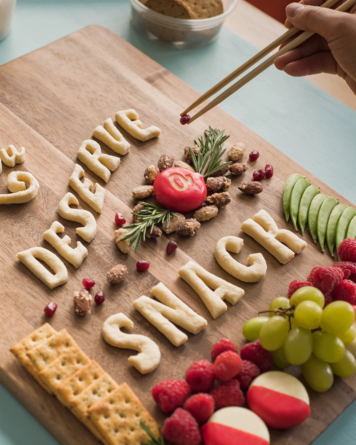 Lauren uses nuts and pomegranate seeds as embellishment on the Babybel "You Deserve a Snack" charcuterie board.