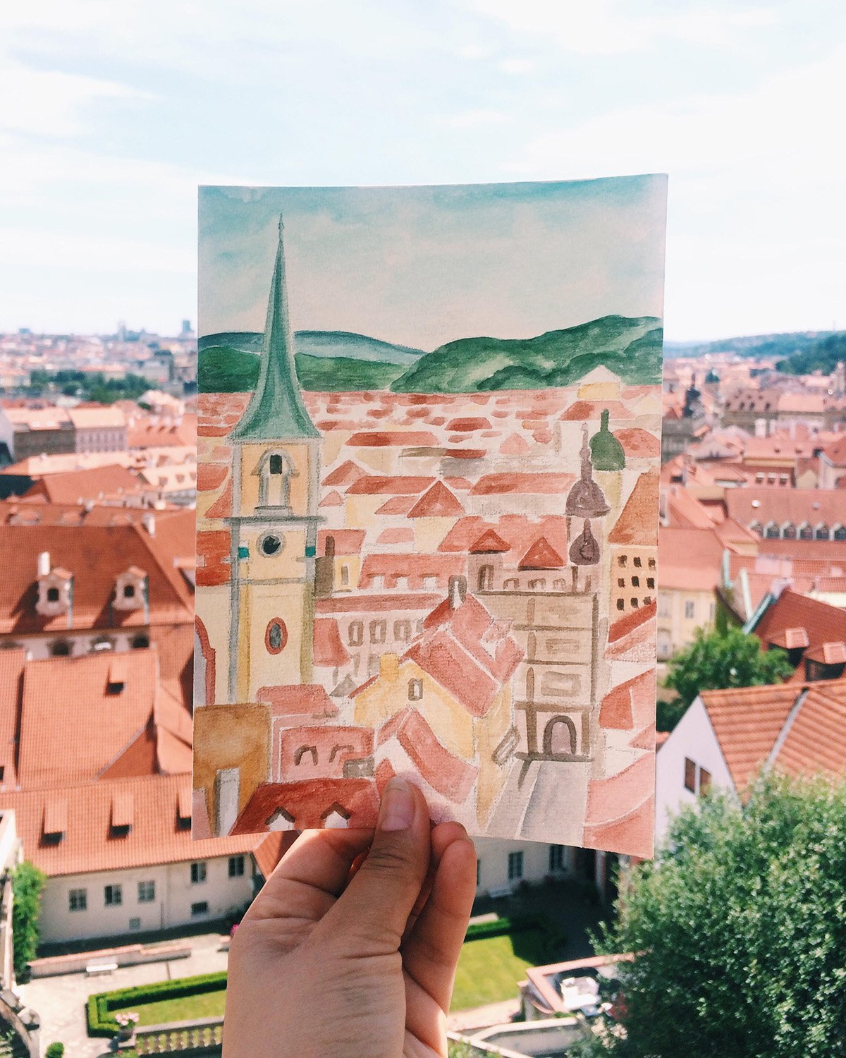 Watercolor painting of view of village rooftops.