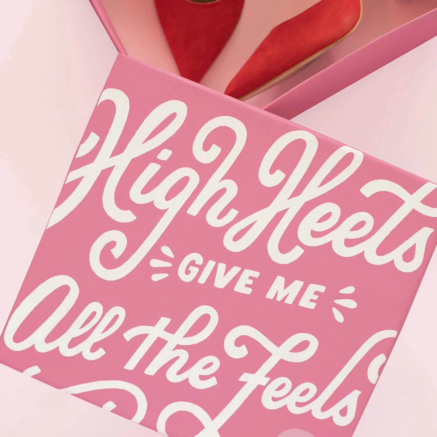Top of pink shoebox reads 'High heels give me all the feels' in white cursive letters.
