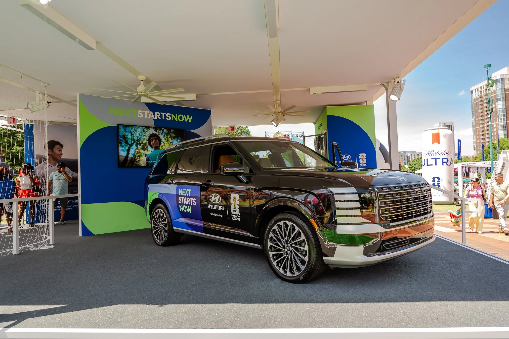Fans participate in the Hyundai soccer challenge at FIFA Fan Fest Atlanta while exploring Hyundai's interactive brand activation featuring a soccer skills experience and vehicle display.