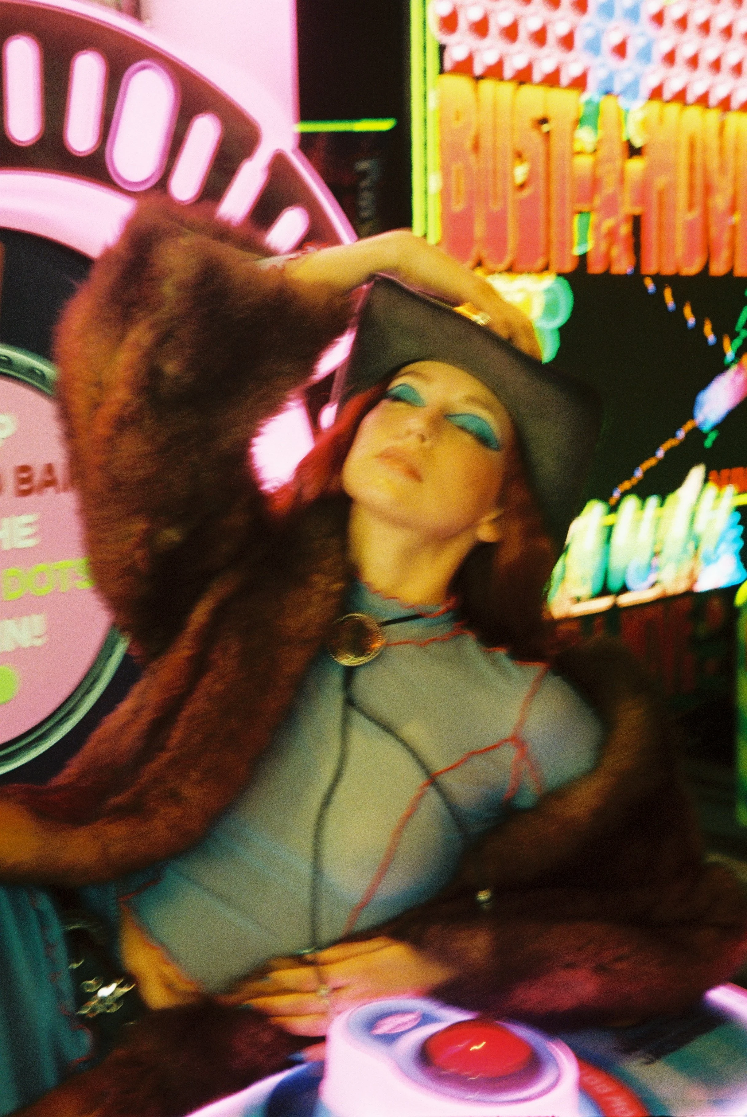 Neon cowgirl-themed photoshoot in an Atlanta arcade – 35mm film shoot with cowboy hat and western styling