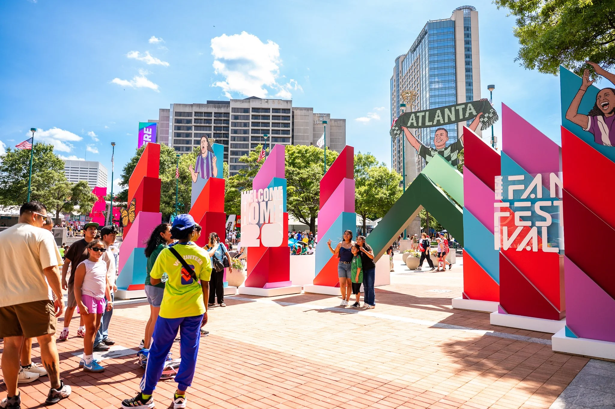 Fans line up to take photos with the FIFA Fan Fest Atlanta sign, demonstrating how iconic event branding creates memorable guest experiences and encourages organic social sharing.