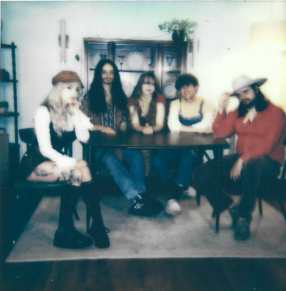 Polaroid band portrait of Atlanta rock group Rae & The Ragdolls, taken at a 1970s midcentury modern home