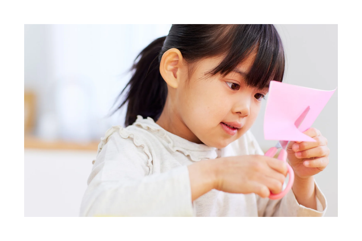 Student completing a fine motor cutting activity during a school-based occupational therapy assessment