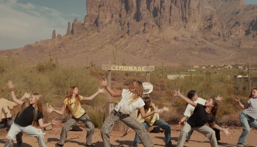 Zara campaign for Gen Alpha featuring teenage girls / youth modeling the latest fashion campaign dancing in front of a lemonade stand in a desert landscape with mountains in the background.
