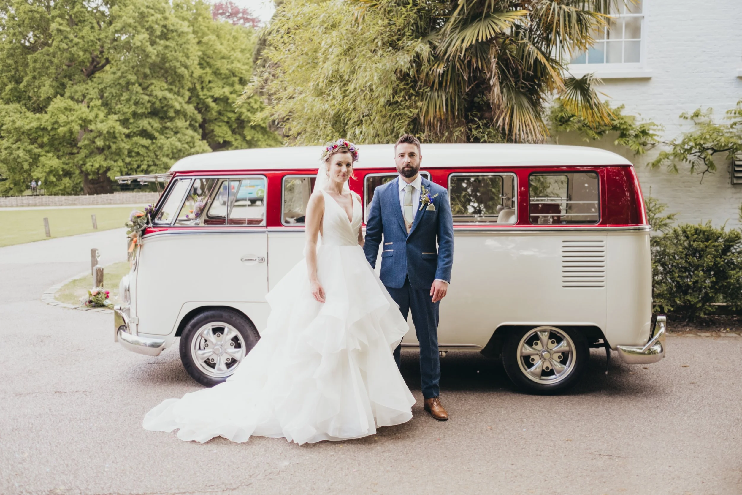 Bride and groom in front of the red & white vintage camper.  A perfect VW camper van for weddings.