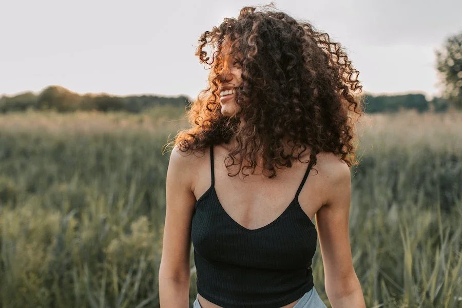 BIPOC woman walking through field smiling