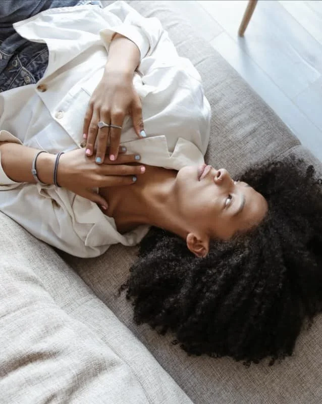 A woman lying down in a white shirt