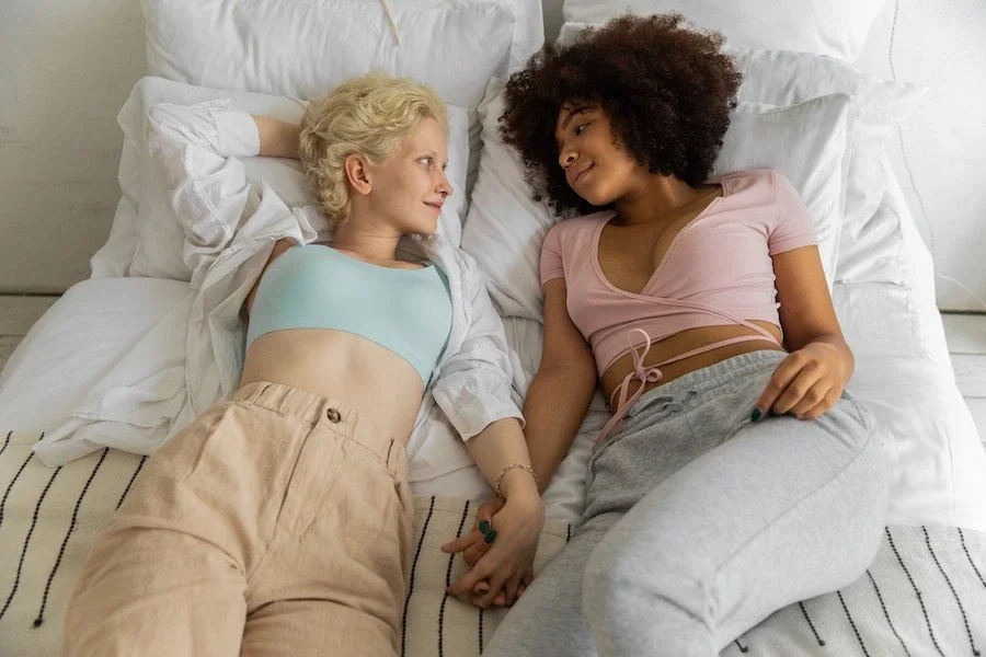Couple holding hands in bed