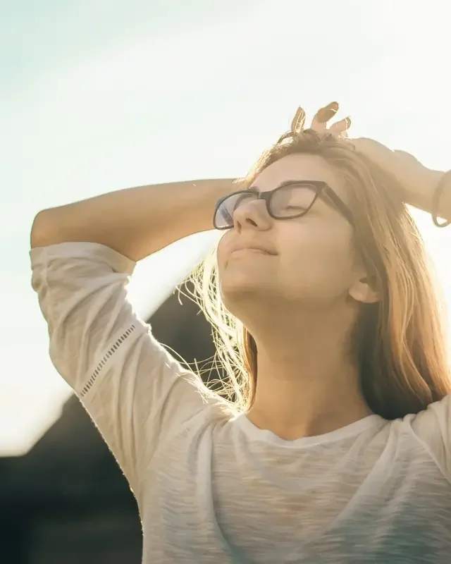 A woman with glasses and hands on her head