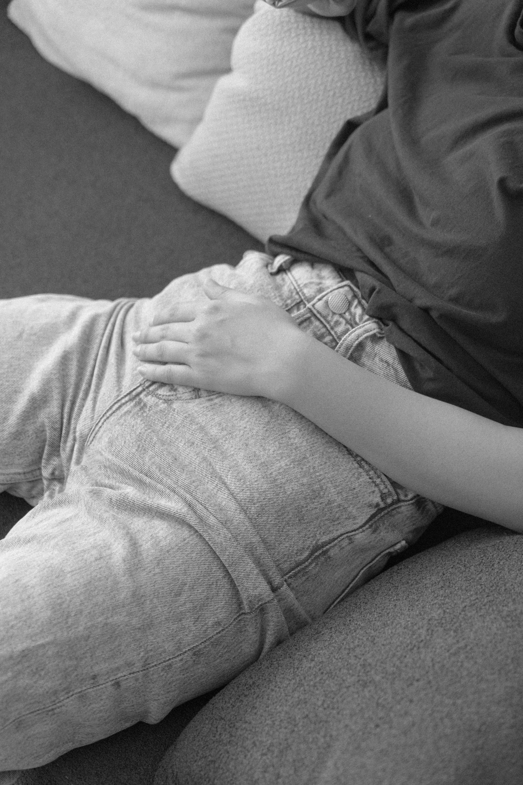 Woman clutching stomach with chronic constipation