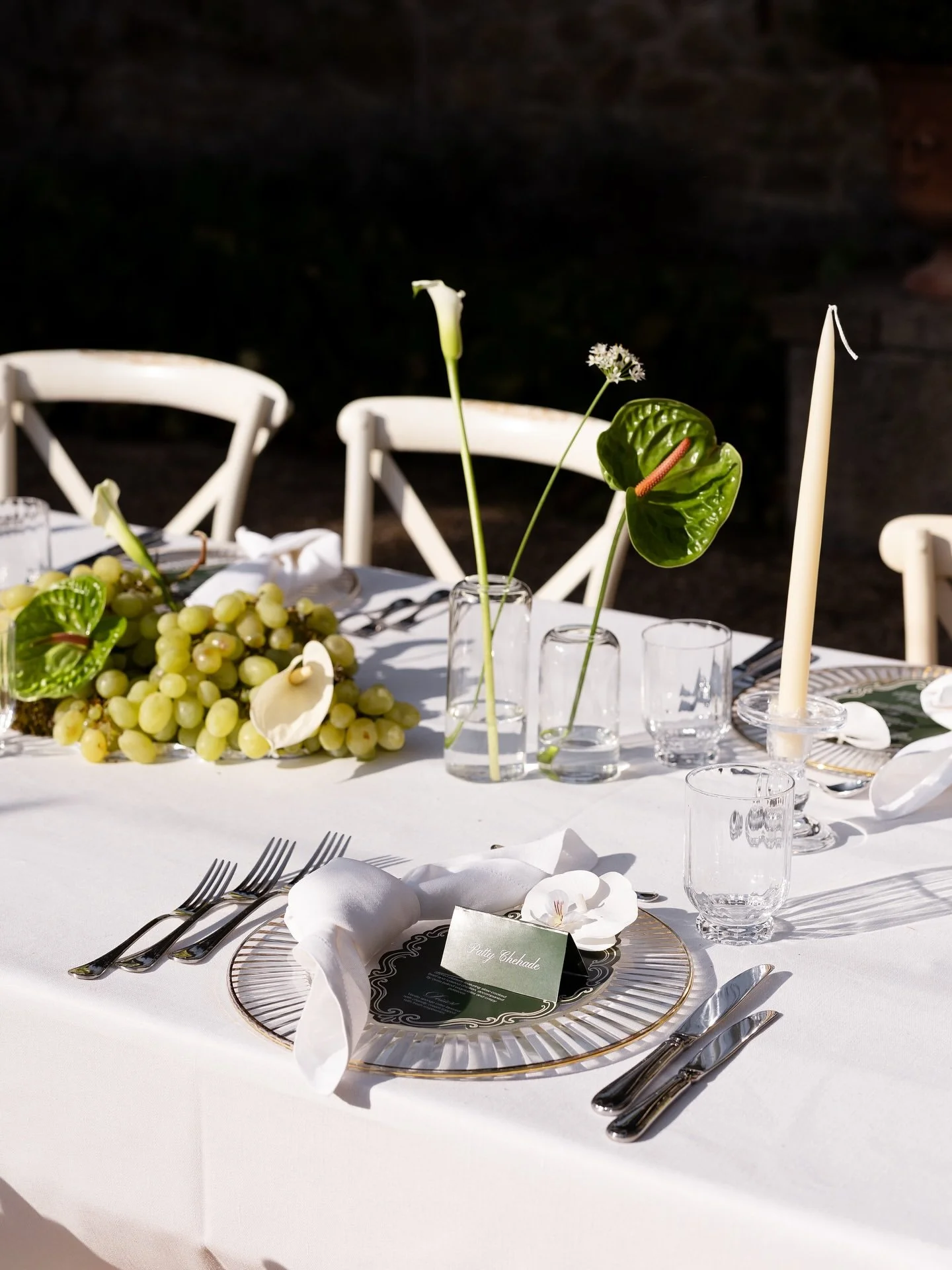 Candlelit wedding table setting with glassware and greenery for the reception in Tuscany