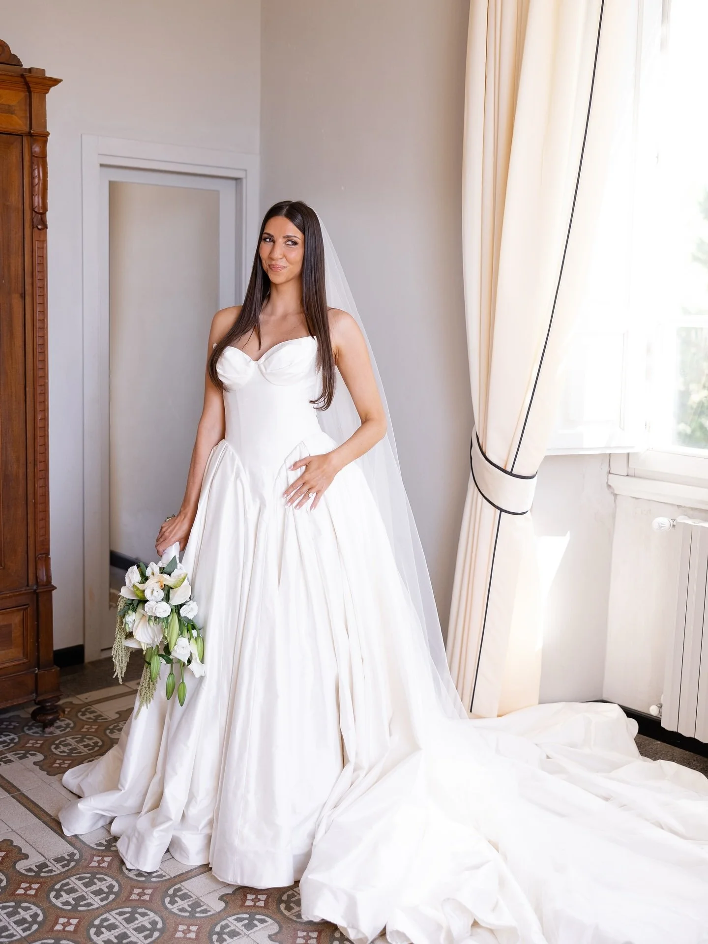 Bride Marilena holding her bouquet in the Leah Da Gloria gown